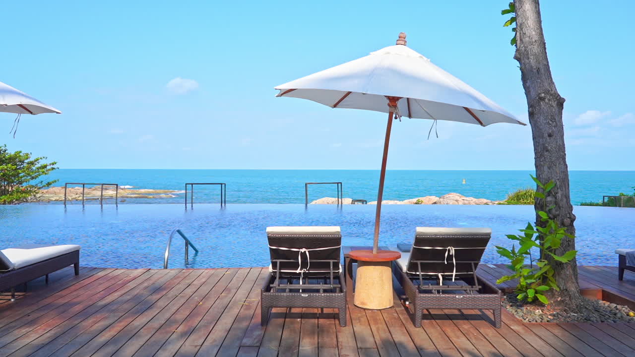 화창한 날에는 선베드와 파라솔이 있는 인도양 기슭의 대형 인피니티 풀