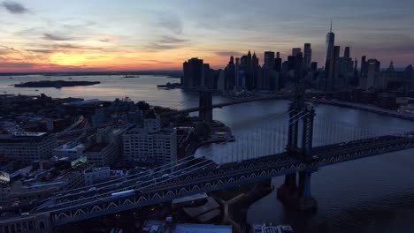 aerial panning shot of manhattan and brooklyn bridge with new york city manhattan skyline distant, dusk