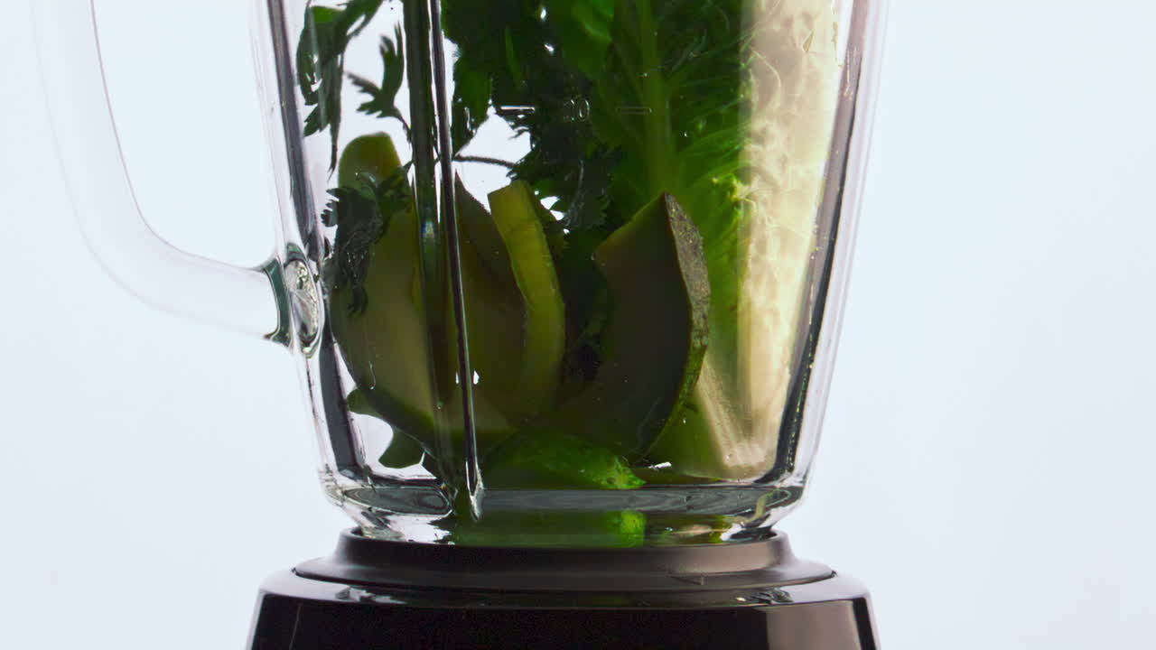 primer plano de las verduras orgánicas que caen en la licuadora a cámara súper lenta. nutrición vegana