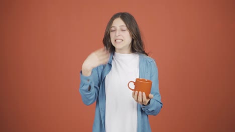 la boca de la joven está ardiendo de la bebida caliente.