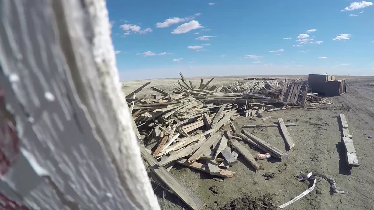 pasando por un cartel de madera hasta un montón de madera vieja usada tirada en medio de la nada