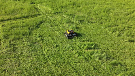 vista aérea de una cortadora de césped robótica automatizada, máquina de cortar césped verde, toma de un avión no tripulado