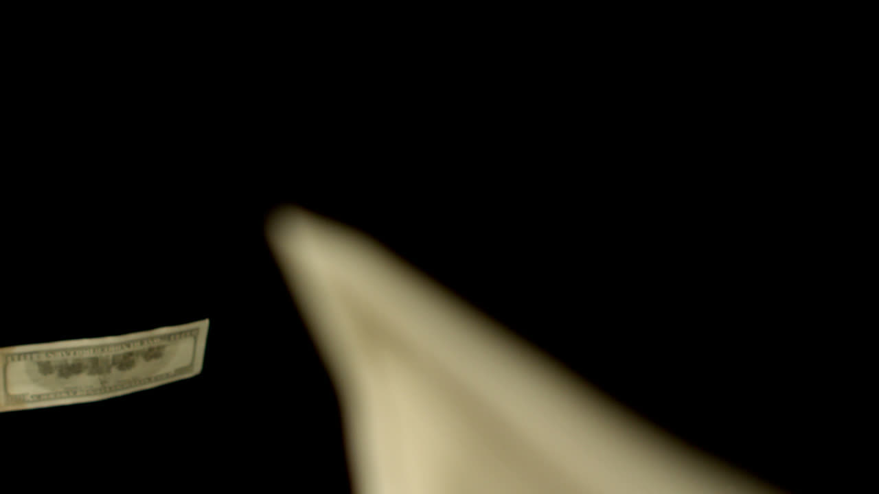 dólares soplando sobre un fondo negro