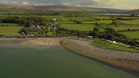 flaggy shore, clare, ireland, august 2020, drone orbits beach with burren landscape in the background