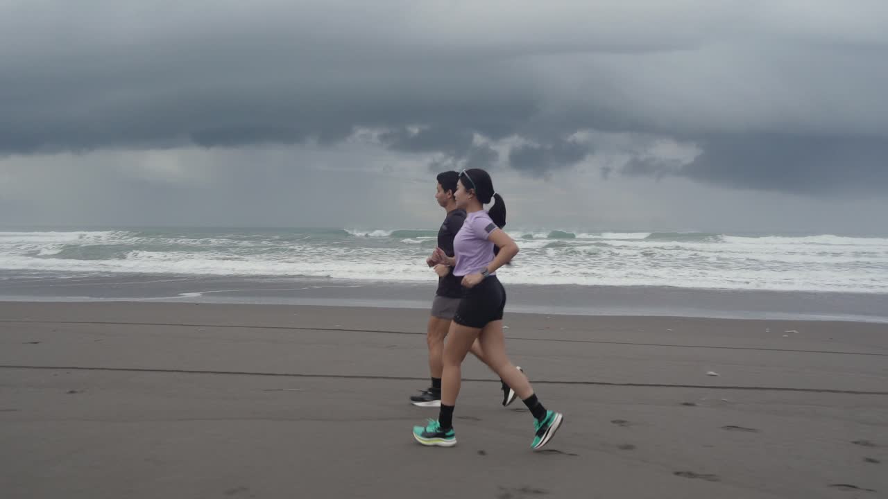 Couple Running on a Beach in Cloudy Weather