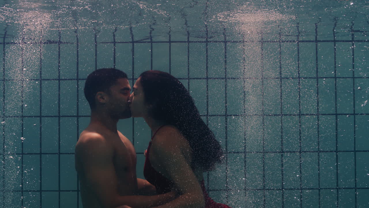 coppia giocosa che si bacia sott'acqua in piscina giovani che si godono un bacio romantico amanti appassionati sommersi nell'acqua che galleggiano con bolle che si godono il romanticismo