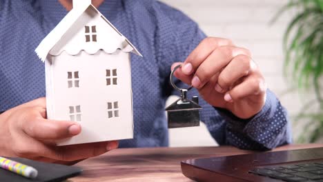 hombre con casa modelo y llave