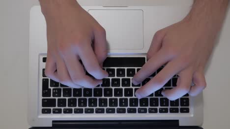 top-view-of-male-hands-typing-on-laptop-keyboard