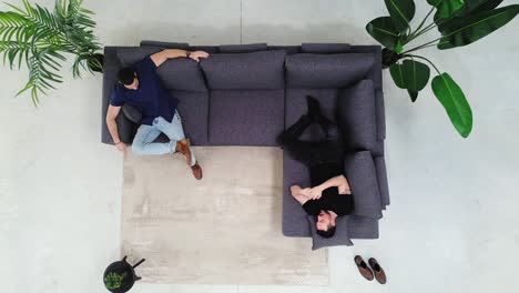 aerial perspective: friends engaging in conversation on the couch. talking men on the sofa at home
