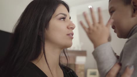 close-up of a smiling middle eastern woman and boy rubbing noses