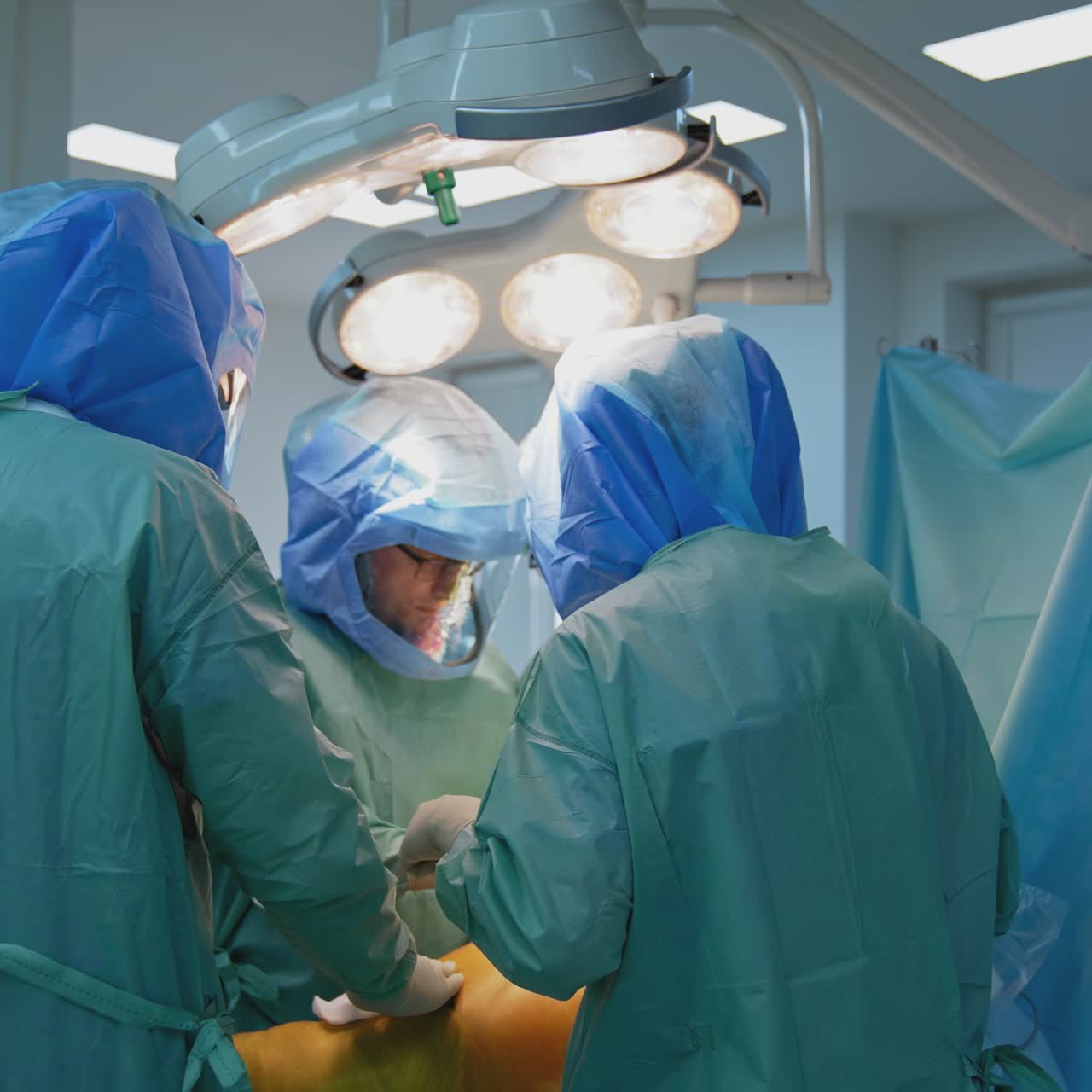 Operating room with surgery in progress. Medical team performing surgical operation in bright modern operating room