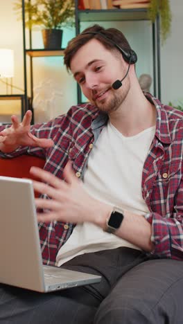 hombre de negocios feliz utiliza la línea de ayuda de portátil haciendo una llamada de videoconferencia en línea a distancia de casa