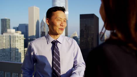 multi ethnic business couple planning projects on rooftop