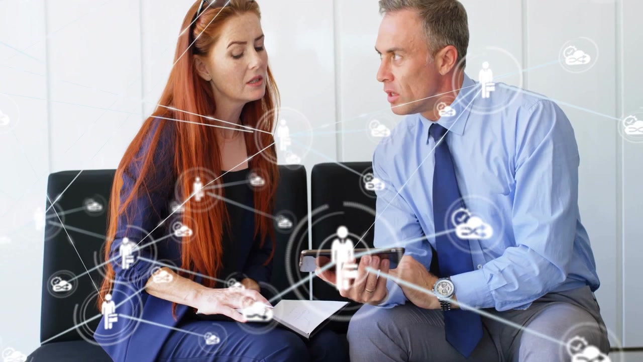 Animation of network of connections with icons over caucasian business people talking in office