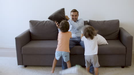 Papá-De-Mediana-Edad-Jugando-Con-Niños-Y-Peleando-Con-Almohadas