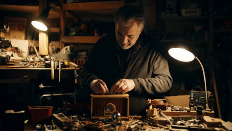 man repairing a vintage radio in a workshop