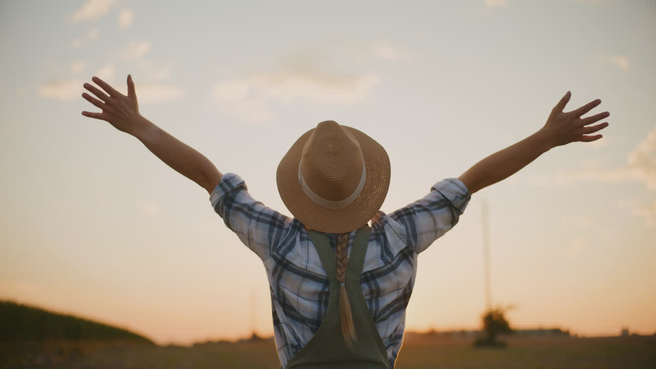 mujer granjera disfrutando de la puesta de sol en el campo