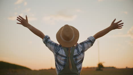 mujer granjera disfrutando de la puesta de sol en el campo