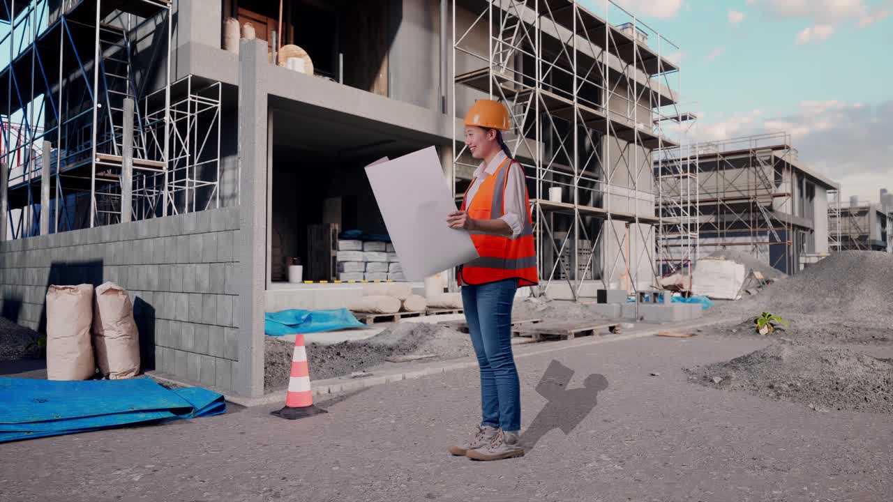 Full Body Side View Of Asian Female Engineer With Safety Helmet Looking At Blueprint In Her Hands While Standing At Construction Site in Progress to New House