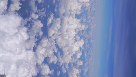 Vertical-view-over-beautiful-fluffy-clouds-against-blue-sky