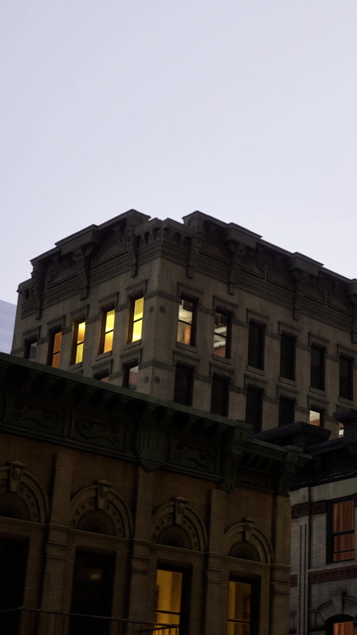 Edificio con finestre illuminate visto dalla strada durante le ore serali