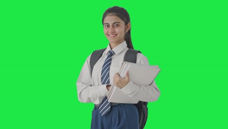 retrato de una estudiante india feliz de pie con libros pantalla verde