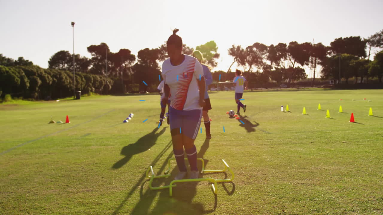 Training on grassy field, soccer players using agility equipment and cones