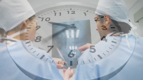 Animation-of-clock-over-diverse-male-and-female-surgeons-discussing-over-x-ray-report-at-hospital