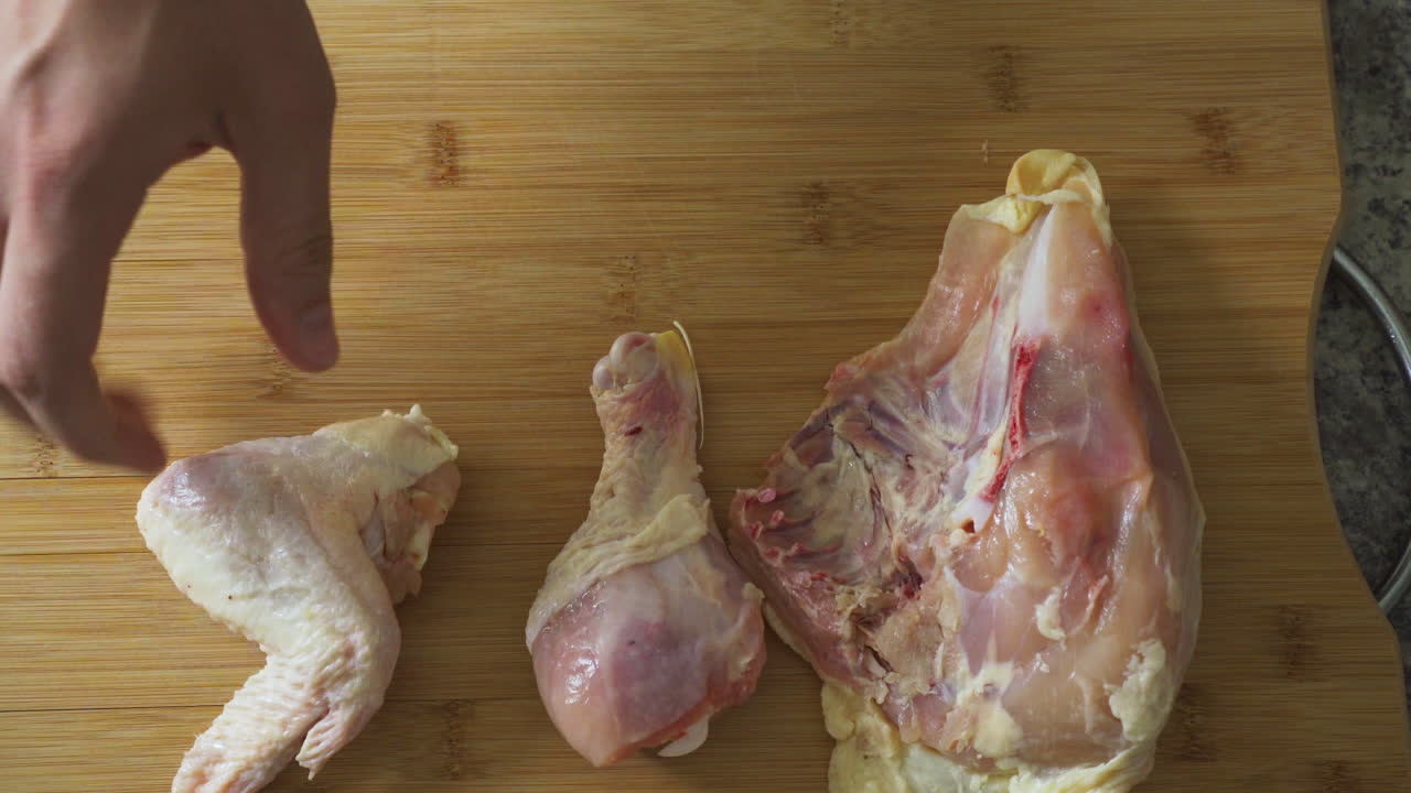 poner pollo crudo en una tabla de cortar