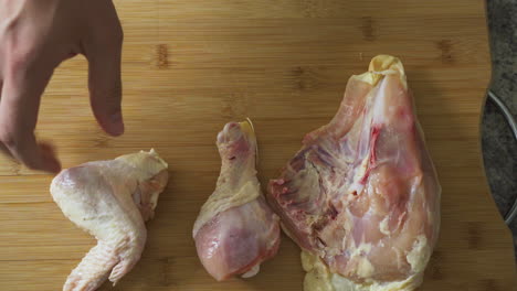 laying raw chicken on a cutting board