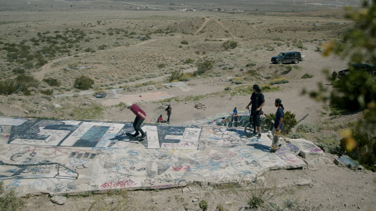 Skateboarding and BMX in a graffiti-covered desert skate spot