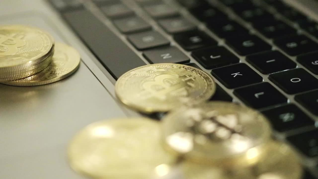 bitcoin moneda de oro en el teclado de la computadora portátil girando en el concepto de comercio en línea