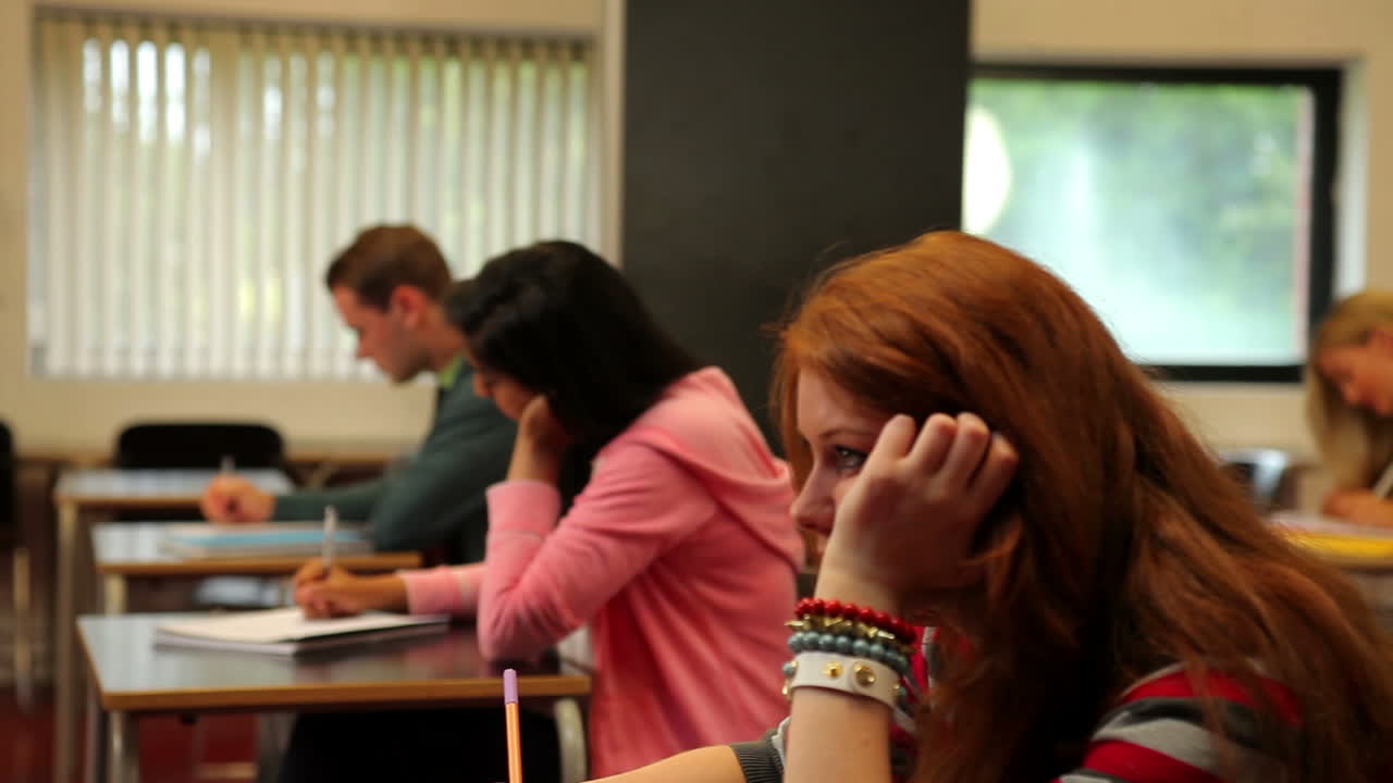 concentración de los estudiantes sentados en un aula y tomando notas