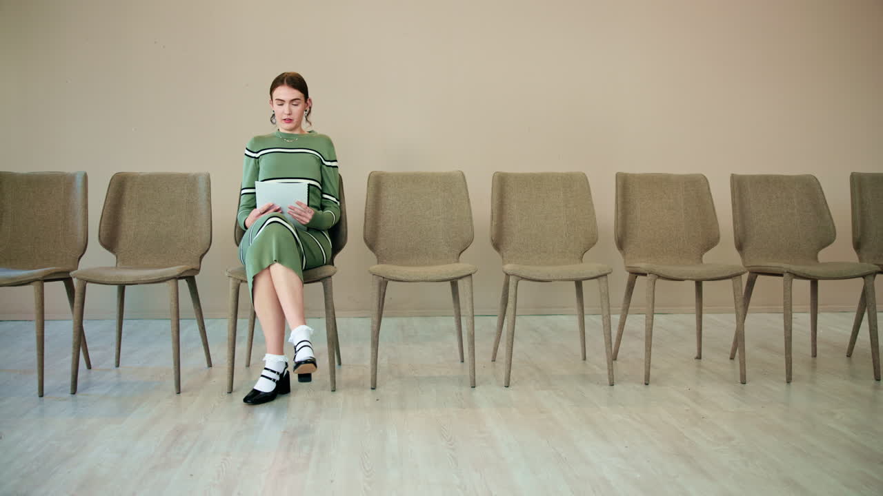 직업 인터뷰 를 위해 대기실 에 앉아 있는 여자