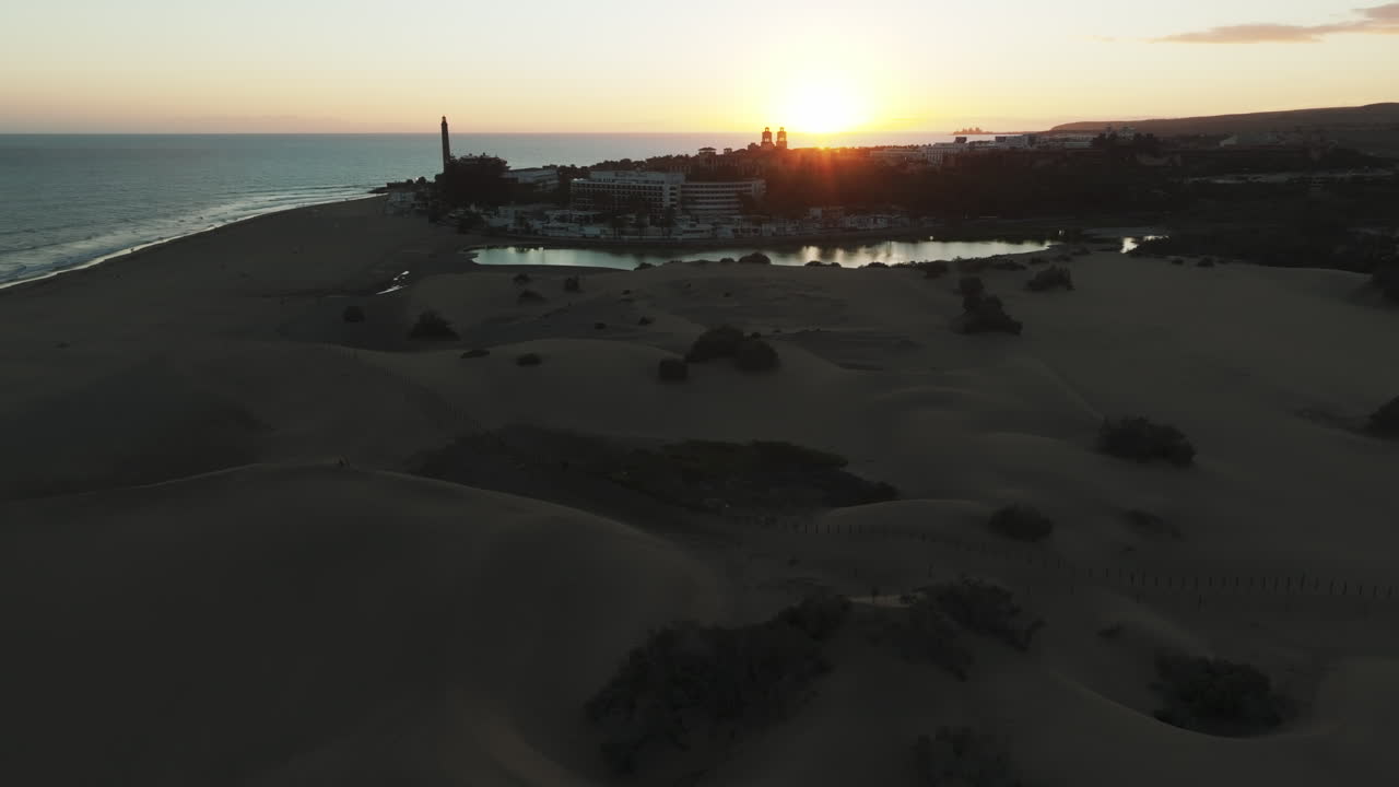 dunas de maspalomas: vista aérea en órbita durante la puesta de sol del estanque y la detección del faro que se encuentra en esta área natural