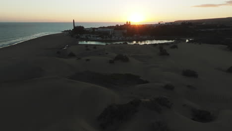 Dünen-Von-Maspalomas:-Luftaufnahme-Im-Orbit-Während-Des-Sonnenuntergangs-Des-Teiches-Und-Der-Sicht-Auf-Den-Leuchtturm,-Der-Sich-In-Diesem-Naturgebiet-Befindet