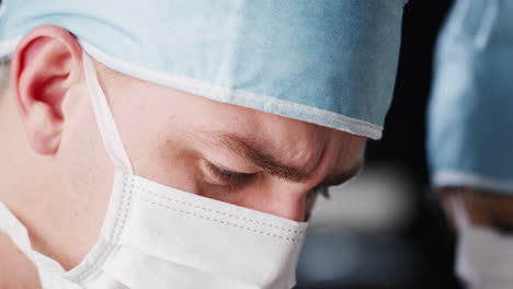 surgeon and medical assistant working, head shot