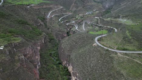 Aerial-view:-Vehicle-traffic-drives-on-switchback-highway-into-valley