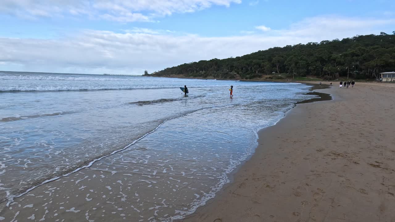 серферы наслаждаются волнами на пляже лорн.