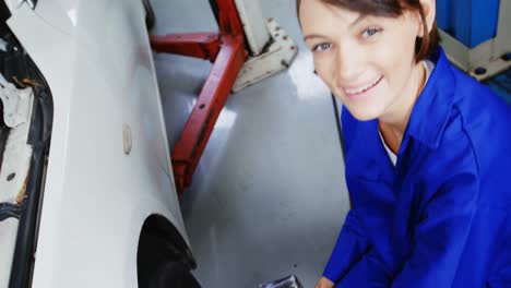 female mechanic fixing a car wheel