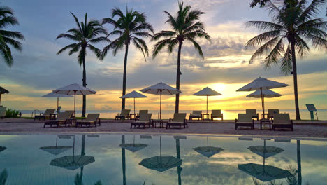 sombrilla y silla alrededor de la piscina en el hotel resort para viajes de placer y vacaciones cerca de la playa del océano al atardecer o al amanecer