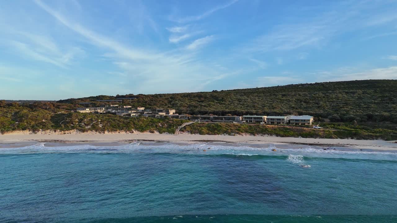 drone volando sobre las olas hacia el complejo de lujo