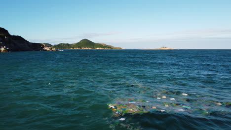 circular view over sea full with rubbish and coastline on background