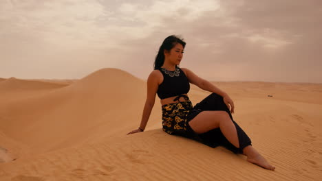 donna che si rilassa su una duna di sabbia nel deserto del sahara