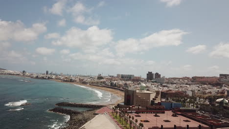 Fantastic-aerial-shot-approaching-the-Alfredo-Kraus-auditorium-and-making-out-Las-Canteras-beach,-on-the-island-of-Gran-Canaria-and-on-a-sunny-day