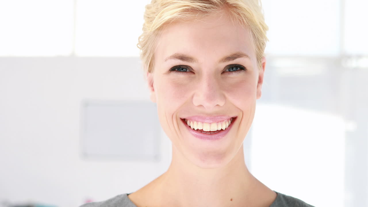 Pretty blonde woman looking at camera in office