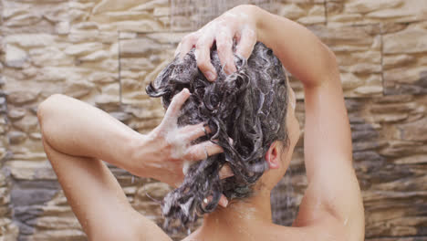 close up of biracial woman taking shower in bathroom