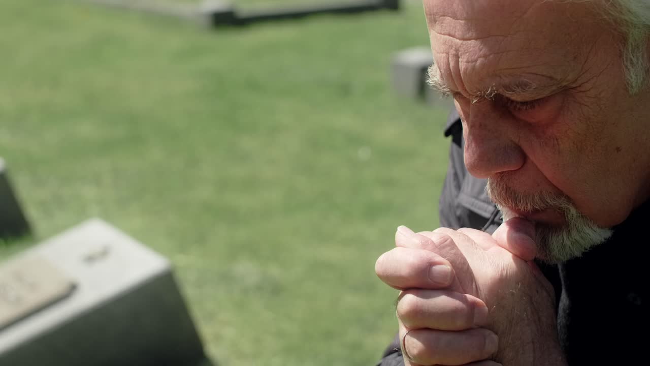 Elderly Man Praying in a Cemetery