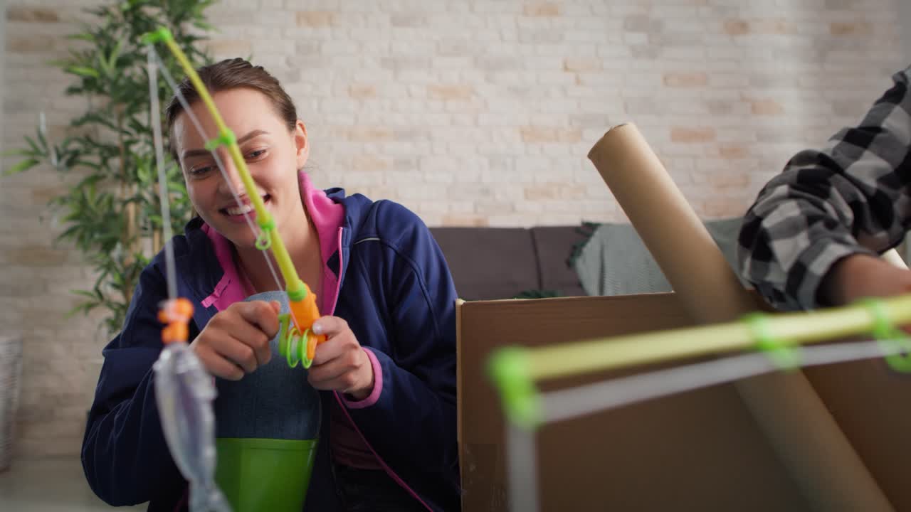 video de madre con hijo jugando a la pesca en casa