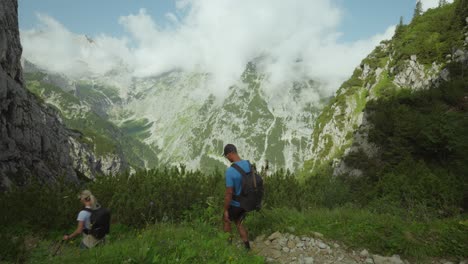 hiking couple in german alps descending along trail with views on zugspitze